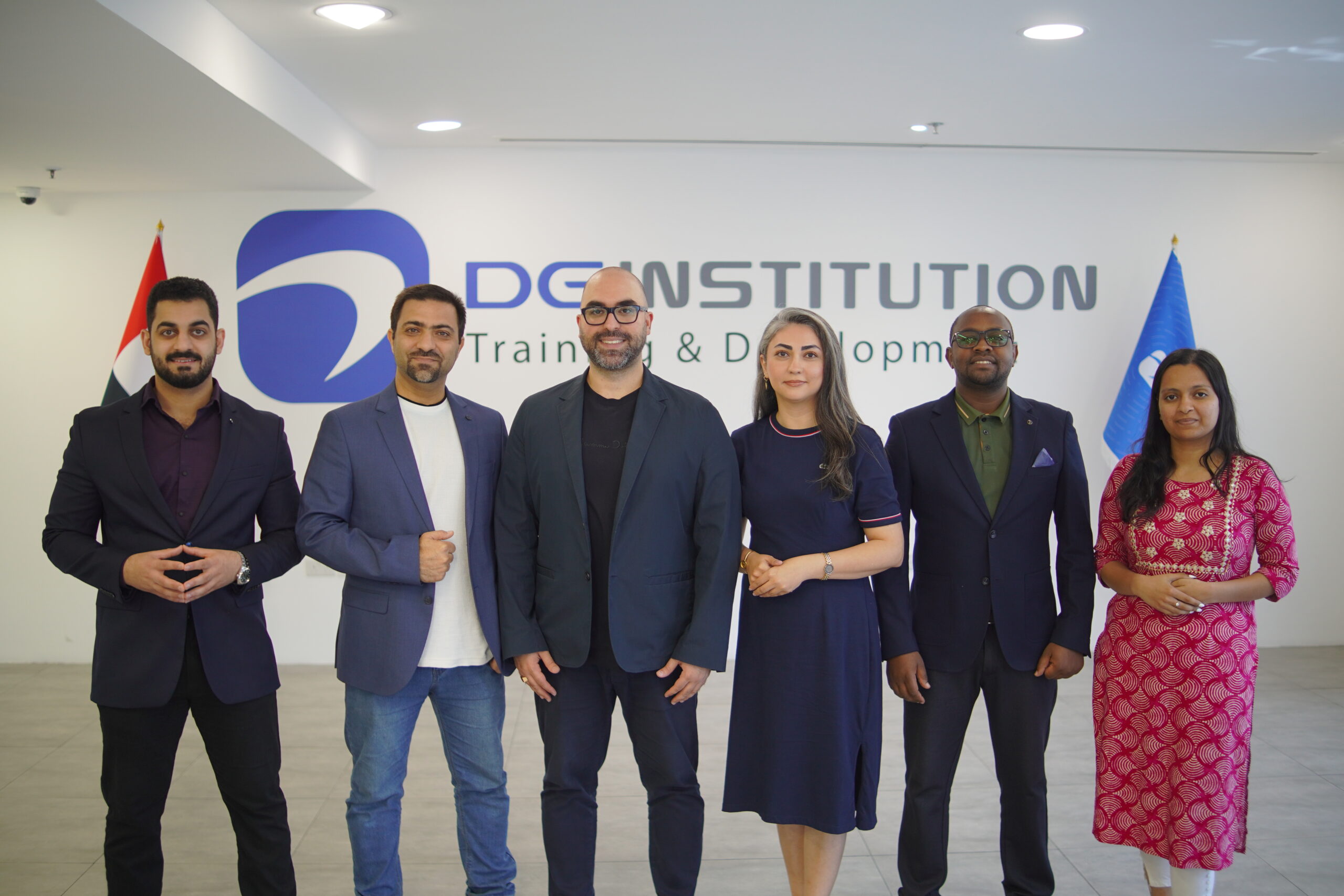 A group of people standing in front of the Dg Institution logo.